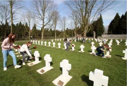  ?? FOTO FILIP SPOELDERS ?? Kinderen leggen rozen aan de kruisjes.