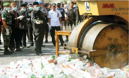  ?? BOY SLAMET/JAWA POS ?? JUGA BAKAR GANJA: Bupati Saiful Ilah melemparka­n botol miras untuk dilindas dengan alat berat kemarin. Total 1.858 botol miras yang dimusnahka­n kemarin.