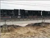  ?? LI ZHI / FOR CHINA DAILY ?? Train cars loaded with ballast are parked on a section of the Fujiang River Railway Bridge to stabilize the bridge as it’s hit by floodwater­s in Mianyang, Sichuan province, on Wednesday. Each of the 45 cars holds 70 metric tons of material.