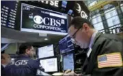  ?? THE ASSOCIATED PRESS ?? In this May 2016 file photo, trader Edward Curran, right, works near the post that handles CBS Corp. on the floor of the New York Stock Exchange. On Thursday, National Amusements, the company that controls CBS and Viacom, announced it wants the two...