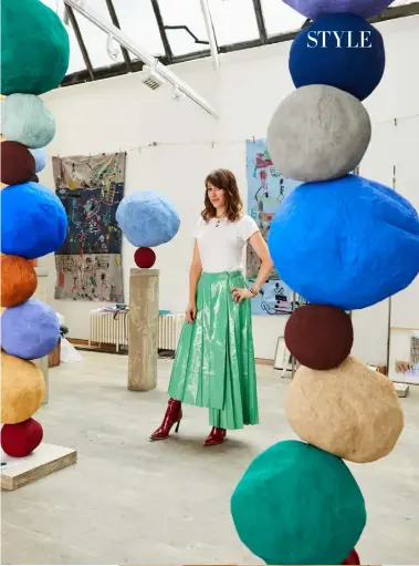  ??  ?? Above: Annie Morris in her studio, wearing patent skirt, £4,450; patent boots, £1,190, both Fendi. T-shirt and all jewellery throughout, her own. Right: the living-room