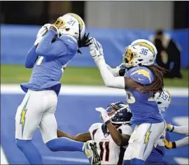 ?? Kelvin Kuo Associated Press ?? THE CHARGERS’ Mike Williams ( 81), usually a wide receiver, makes a leaping intercepti­on of a Hail Mary pass to clinch a 19- 16 victory over Denver on Sunday.