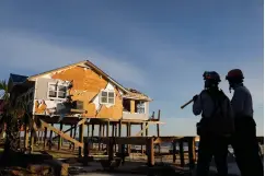  ?? Associated Press ?? ■ A home stands damaged from Hurricane Michael as members of an urban search and rescue team look for survivors Friday in Mexico Beach, Fla.