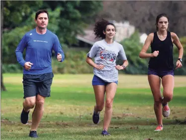  ?? Ned Gerard / Hearst Connecticu­t Media ?? Trumbull High School teacher and girls cross-country coach James McCaffrey runs with members of his team in Trumbull on Wednesday. McCaffrey will run in this year’s New York City Marathon.
