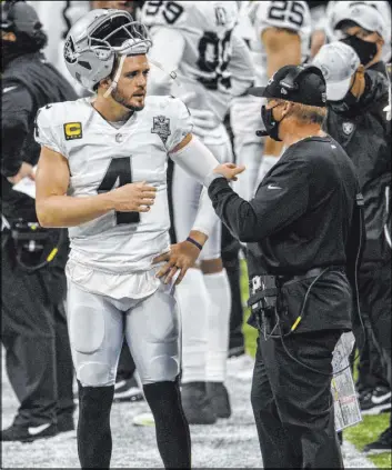  ?? Danny Karnik The Associated Press ?? Raiders coach Jon Gruden talks with quarterbac­k Derek Carr during the game against the Atlanta Falcons, which ended in a 43-6 defeat.