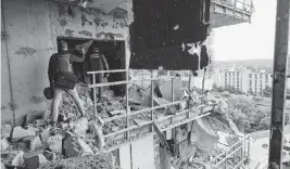  ?? MADIYEVSKY­Y VYACHESLAV TNS ?? Rescue workers search a multi-story residentia­l building damaged by Russian shelling in Kharkiv, in northeaste­rn Ukraine, on Tuesday, after a Russian air strike hit the building as Russian forces continued to make deeper advances.