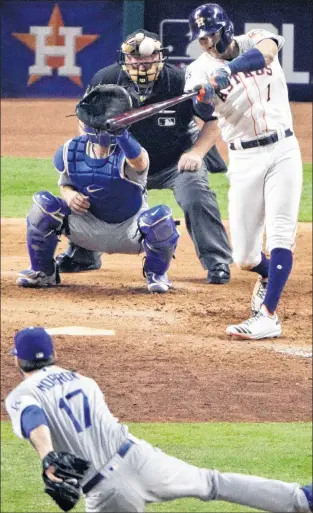  ?? AP PHOTO ?? Houston Astros’ Carlos Correa hits a two-run home run off Los Angeles Dodgers relief pitcher Brandon Morrow during the seventh inning of Game 5 of baseball’s World Series on Sunday, in Houston. Bullpens for both teams are taking a beating in this...