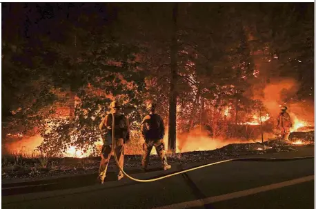  ?? AFP ?? Wall of flames: Firefighte­rs trying to contain the Carr wildfir as it spreads towards the town of Douglas City near Redding, California. —