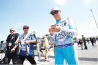  ?? AP Photo/colin E. Braley ?? ■ Kevin Harvick, right, signs autographs as he heads to pit road May 15 before the start of a NASCAR Cup Series auto race at Kansas Speedway in Kansas City, Kan.