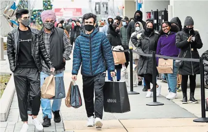  ?? NATHAN DENETTE THE CANADIAN PRESS ?? Masked customers line up at the Toronto Premium Outlets mall in Halton Hills on Black Friday for shopping sales.