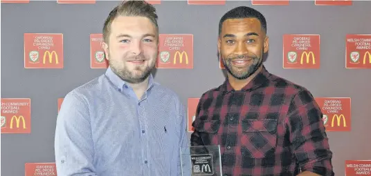  ??  ?? ● Gethin Jones from Porthmadog Football in the Community receives his award from Jermaine Easter