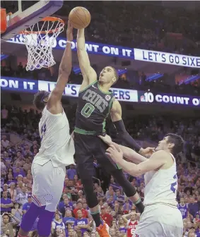  ??  ?? RIM SHOT: Jayson Tatum goes up to shoot between Joel Embiid (left) and Ersan Ilyasova during the second half of Game 3 yesterday in Philadelph­ia.