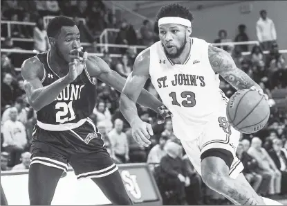  ?? Andrew Theodoraki­s ?? MARVELOUS MARVIN: Marvin Clark II, who led St. John’s with 21 points and had 14 in the first half to keep Mount St. Mary’s at bay, moves the ball past Collin Nnamene during the Red Storm’s 85-71 win.