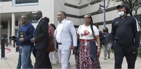  ?? AP PHOTOS ?? TAKING A STAND: Attorney Ben Crump, second from left, walks with Ron Lacks, left, Alfred Lacks Carter, third from left, both grandsons of Henrietta Lacks, and other descendant­s of Lacks, whose cells have been used in medical research without her permission, outside the federal courthouse in Baltimore, Monday. They announced during a news conference that Lacks’ estate is filing a lawsuit against Thermo Fisher Scientific, seen above in Waltham, for using Lacks' cells, known as HeLa cells.