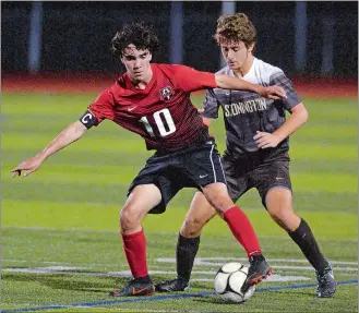  ?? DANA JENSEN/THE DAY ?? Fitch’s Caleb Robbins (10) fights to keep control of the ball against Stonington’s Max Wojtas (19) during Wednesday’s ECC Division I boys’ soccer match at Stonington.