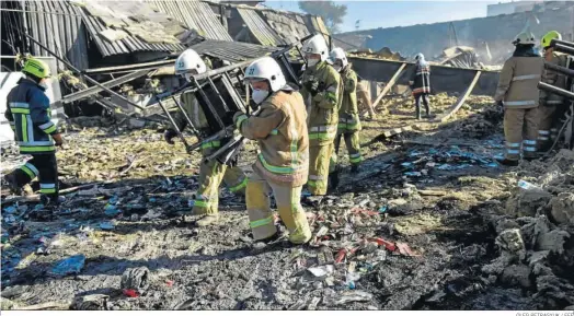  ?? OLEG PETRASYUK / EFE ?? Los bomberos hacen labores de limpieza ayer de los escombros del destruido centro comercial Amstor en Kremenchuk (Ucrania).