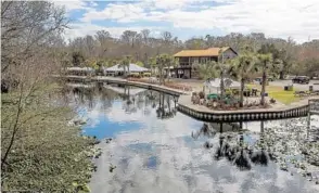  ?? PHOTOS BY JACOB LANGSTON/STAFF PHOTOGRAPH­ER ?? The calm Wekiva River flows past Wekiva Island on Thursday. Owners Bill and Mary Sue Weinaug hope to expand the complex, but some nearby residents object. Below, a couple canoes by the complex.