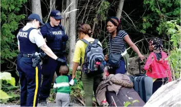  ?? PHOTO MARIE-ÈVE DUMONT ?? Les migrants rencontren­t aux États-unis des agents de la Gendarmeri­e royale du Canada avant de traverser la frontière canado-américaine sur le rang Roxham.