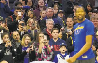  ?? Mitchell Leff / Getty Images ?? Fans take videos and pictures of Warriors forward Kevin Durant before a game in Philadelph­ia in March. His impending free agency has been a popular topic in the NBA.