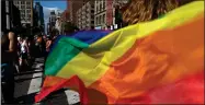  ?? AP PHOTO BY WONG MAYE-E ?? In this June 30, 2019, file photo parade-goers carrying rainbow flags walk down a street during the LBGTQ Pride march in New York, to celebrate five decades of LGBTQ pride, marking the 50th anniversar­y of the police raid that sparked the modern-day gay rights movement.