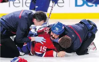  ?? R I C H A R D WO L O WI C Z / G E T T Y I MAG E S ?? George Parros is tended to by Canadiens staff after falling head first on the ice and suffering a concussion during a fight in the Habs’ 2013 season opener against the Toronto Maple Leafs.