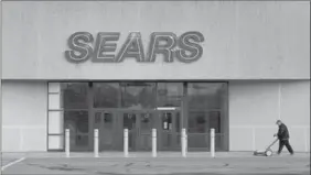  ?? ANDREW VAUGHAN, THE CANADIAN PRESS ?? A worker cleans the sidewalk outside a closed Sears store in Dartmouth, N.S.