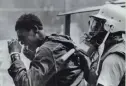  ?? AP ?? A man rubs tear gas from his eyes while he’s escorted from “Resurrecti­on City” in Washington by a police officer on June 24, 1968.