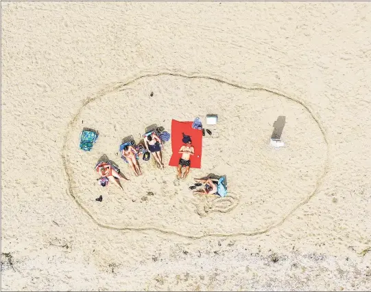  ?? Patrick Sikes / For Hearst Connecticu­t Media ?? A family carves out some space in the sand at Cove Island Park in Stamford on May 5, observing social distancing during the COVID-19 pandemic.