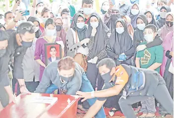  ?? — AFP photo ?? Refa (centre right-spotted top) looks toward the coffin with family members as they attend his funeral in Jakarta.