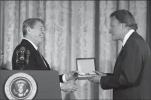  ?? Ronald Reagan Presidenti­al Library ?? Rev. Billy Graham, who died Tuesday at age 99, receives the Presidenti­al Medal of Freedom from President Ronald Reagan at the White House on Feb. 23, 1983.