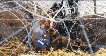  ?? Robert Gauthier Los Angeles Times ?? SENATE Republican­s have linked GOP support for Ukraine to border policy changes that would limit the f low of migrants across the border with Mexico. Above, a family tries to enter the U.S. at Eagle Pass, Texas.