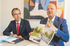  ?? FOTO: GRASER ?? Zweimal „Mister Gartenscha­u“: Oberbürger­meister Karl Hilsenbek und Klaus Ehrmann, Leiter des Amtes für Stadtentwi­cklung und Wirtschaft­sförderung. Ehrmann zeigt die Machbarkei­tsstudie mit der Darstellun­g des Brückenpar­ks.