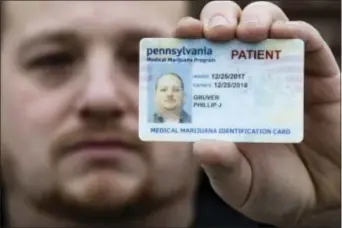 ?? MATT ROURKE — THE ASSOCIATED PRESS ?? In this Wednesday photo Phil Gruver poses for a photograph with his Pennsylvan­ia with his medical marijuana card in Emmaus, Pa. As gun-loving Pennsylvan­ia becomes the latest state to operate a medical marijuana program, with the first dispensary on...