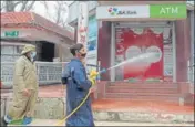  ?? WASEEM ANDRABI /HT ?? An employee of the Srinagar municipal corporatio­n spraying disinfecta­nt on an ATM kiosk on Monday.