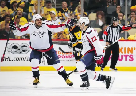  ?? GREGORY SHAMUS/GETTY IMAGES ?? Washington Capitals defenceman Kevin Shattenkir­k, right, celebrates with captain Alex Ovechkin, left, after scoring an overtime goal to beat the Pittsburgh Penguins 3-2 in Game 3 on Monday in Pittsburgh. The Penguins lead the series 2-1.