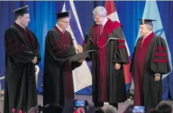  ?? JACK GUEZ/ AFP/GETTY IMAGES ?? Prime Minister Stephen Harper is presented with an honorary doctorate Wednesday by Tel Aviv University president Prof. Yosef Klafter.