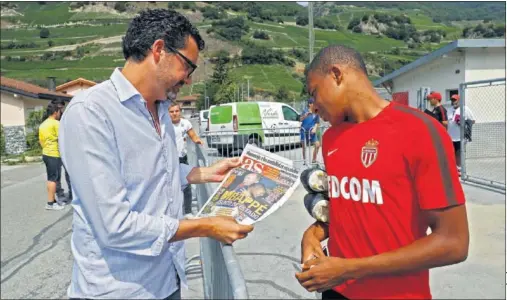  ??  ?? SONRISA. Mbappé se echó a reír amablement­e cuando el enviado de AS le enseñó la portada en la que salía su foto con Alberto de Mónaco.