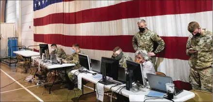  ?? PHOTOS BY JOHN RABY/ASSOCIATED PRESS ?? Members of the West Virginia National Guard monitor statewide efforts to distribute COVID-19 vaccines on Thursday at the National Guard Joint Forces headquarte­rs in Charleston. The state has drawn praise from HHS Secretary Alex Azar.