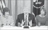  ?? Michael Reynolds European Pressphoto Agency ?? SENS. SUSAN COLLINS, left, and Lisa Murkowski f lank President Trump. The two cast key votes against the Senate GOP healthcare bill.