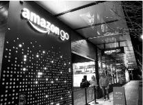  ??  ?? Employees outside an Amazon Go brick-and-mortar grocery store in Seattle. The company has an ambitious collection of technologi­cal experiment­s under way at some of these stores