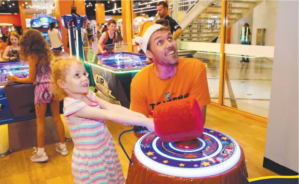  ?? Picture: STEWART McLEAN ?? GOOD BREAK: Alex Loughton with his daughter Ivy, 6, at the Taipans Members Christmas Party at iPlay, Cairns Central Shopping Centre.