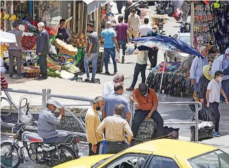  ?? AFP ?? Iranians walk past shops in Tehran on Tuesday. Iran has experience­d the deadliest outbreak of the coronaviru­s disease (COVID-19) in the Middle East.