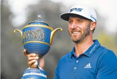  ?? THE ASSOCIATED PRESS ?? Dustin Johnson poses with the Gene Sarazen Cup after winning the Mexico Championsh­ip in his debut performanc­e as the world’s top-ranked golfer at Chapultepe­c Golf Club in Mexico City on Sunday.