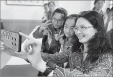  ?? PHOTOS PROVIDED TO CHINA DAILY ?? Right: Scientist Yang Qian takes a selfie with students at the school.