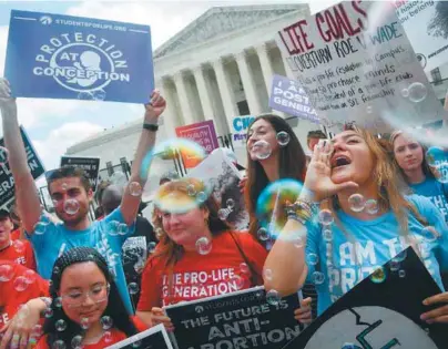  ?? / AFP ?? Activistas contra el aborto celebran frente a la Corte Suprema de EE. UU., en Washington.