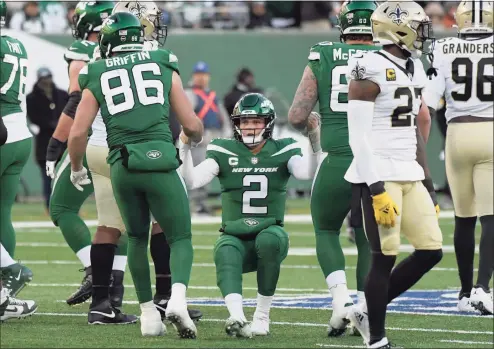  ?? Bill Kostroun / Associated Press ?? Jets quarterbac­k Zach Wilson (2), center, is helped up after being sacked during the second half of Sunday’s game against the Saints in East Rutherford, N.J.