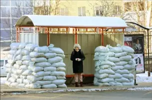  ?? AFP via Getty Images ?? A woman waits at a bus stop protected with sandbags Saturday following recent alleged Ukrainian shelling attacks in Belgorod, the main city of Russia’s southweste­rn Belgorod region bordering Ukraine.