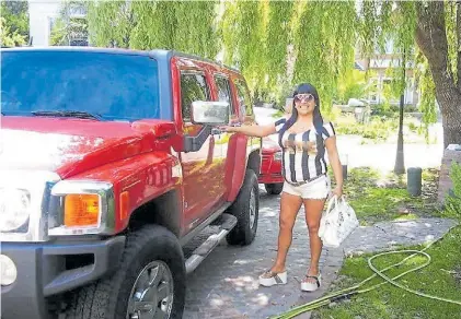  ??  ?? “Patricia”. Gladys Fabiana Fernández junto a su Hummer roja en el country Saint Thomas de Hurlingham.