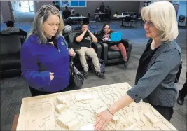  ?? Natalie Bruzda ?? Las Vegas Review-journal Janelle Benedetti, counselor at the College of Southern Nevada, left, and Sherri Payne, senior associate vice president of facilities management at CSN, review a model Wednesday showing the location of a new student union on...