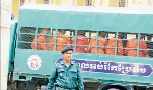  ?? HENG CHIVOAN ?? Jailed Radio Free Asia reporters sit among prisoners transporte­d to the Supreme Court on Monday.